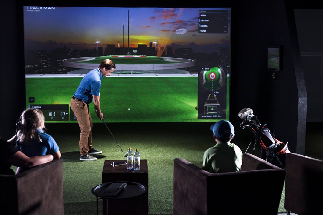 Family playing bullseye on a Trackman Golf simulator